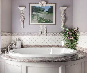 Closeup of gorgeous white soaking tub in lavender and white bathroom