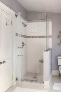Walk in shower in lavender and white tile bathroom
