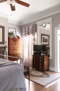 Bedroom corner window with armoire and large mirror
