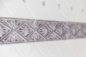 Closeup of custom floral tile in white and lavender bathroom