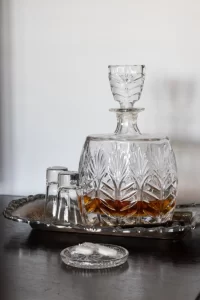 Brandy in glass decanter on antique metal serving tray