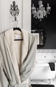 Plush robe on decorative iron door hanger with upscale bathroom in background