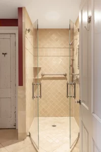 Walk-in, tan-colored tile shower in bathroom