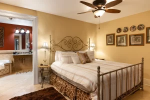 Warm, refined bedroom with view to bathroom with soaking tub
