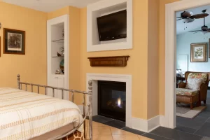 Cozy bedroom with view of double-sided fireplace and living room