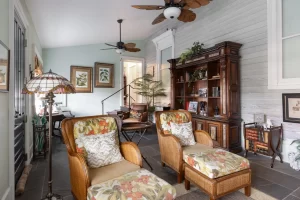 Elegant, soft green living room area with antique wooden furniture and hints of tropical decor