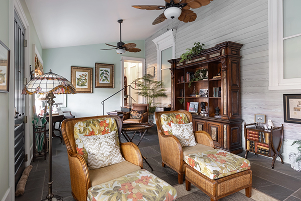 William Riley Suite - soft green living room area with antique wooden furniture and hints of tropical decor