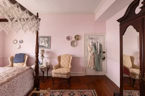 Canopy bedroom view of seating area, closet, and armoire