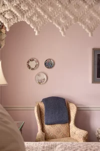 Seating area and porcelain wall art viewed through canopy bed
