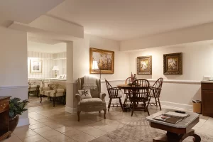 Isabella's Suite living room with 4-seat dining table and view to bedroom with 2 beds