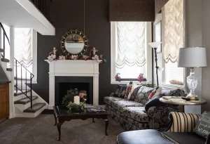 The Loft earth tones colored living room area with couch, decorative fireplace, and windows