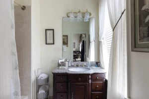 Olivia's Room bathroom with cute vanity, window, and tile shower