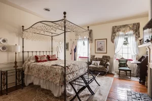 Olivia's Room bedroom with canopy bed, windows, seating area, and desk