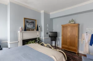 Peyton Mae bedroom with armoire and decorative fireplace