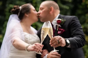 Couple toasting champagne and kissing at their wedding in Fredericksburg VA at The Richard Johnston Inn