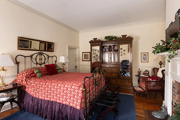 The Virginian patriotic red, white, and blue bedroom with large mirrored armoire and decorative fireplace